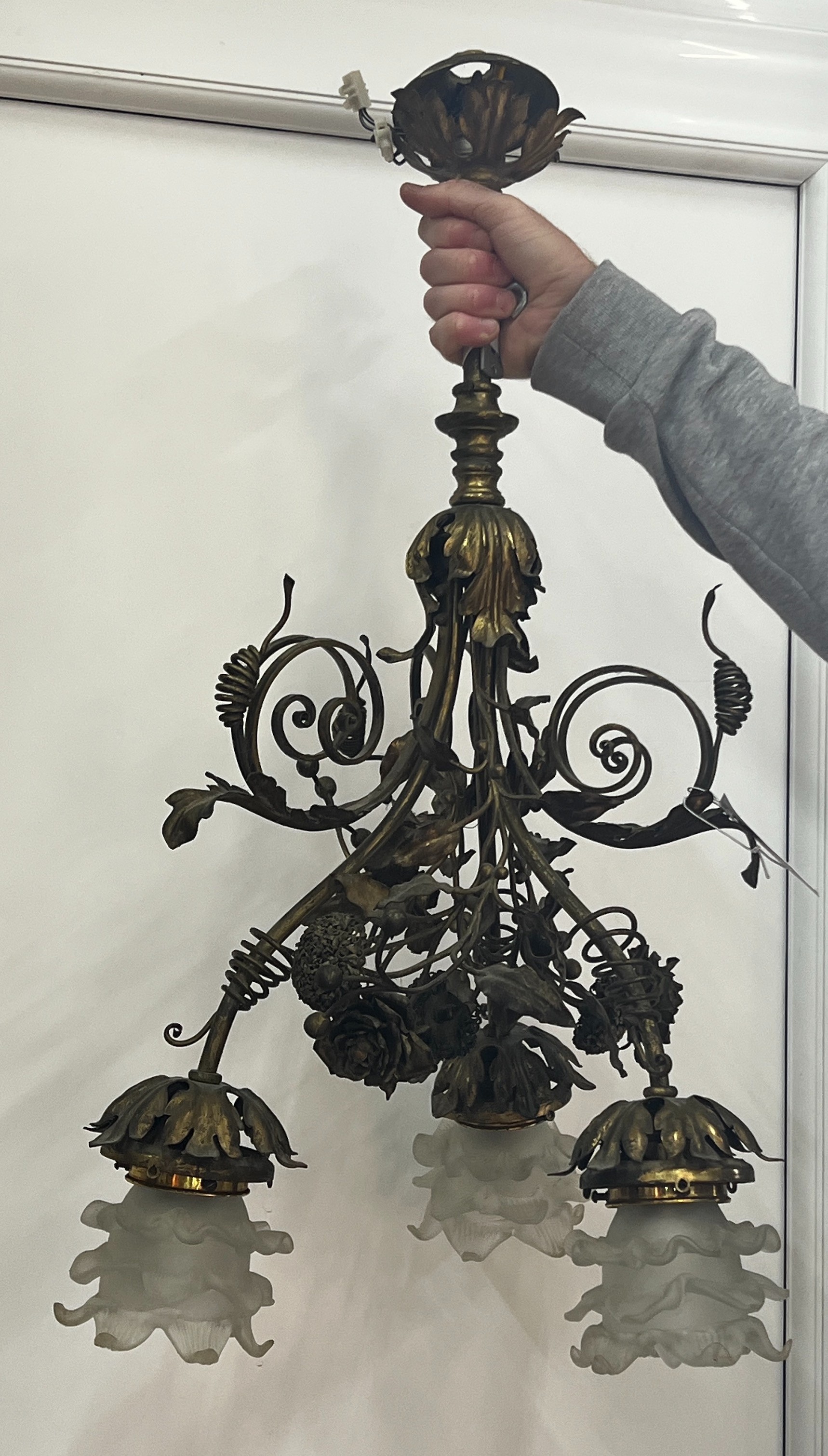 An early 20th century French brass three branch ceiling light with opaque glass shades, height 68cm